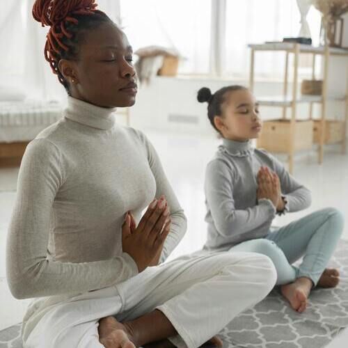 Une adulte et une enfant en position de yoga