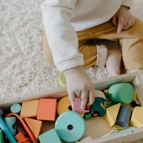 Main d'enfant qui attrape une forme géométrique rose